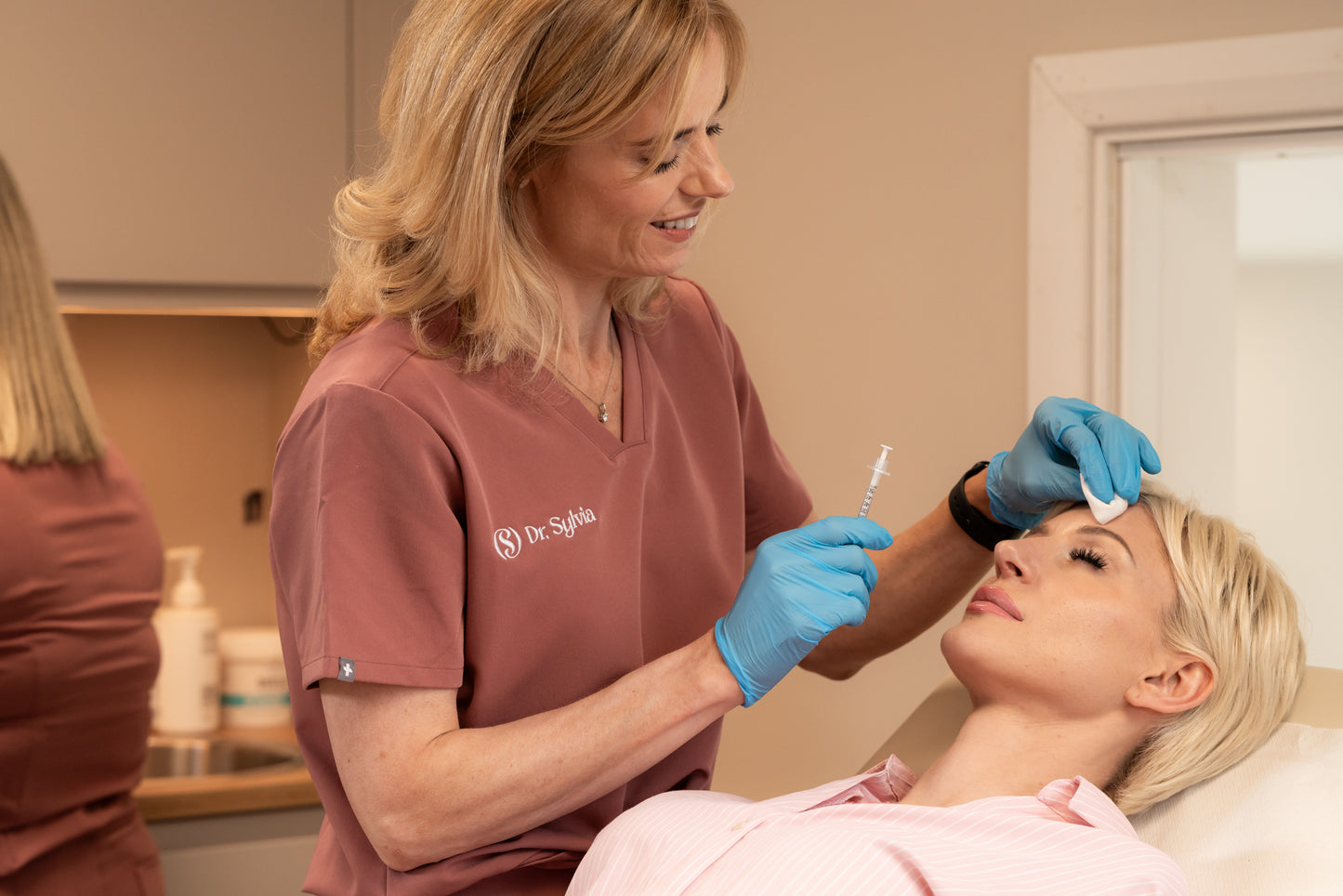 Woman receiving a facial injection from a professional in a clinical setting.